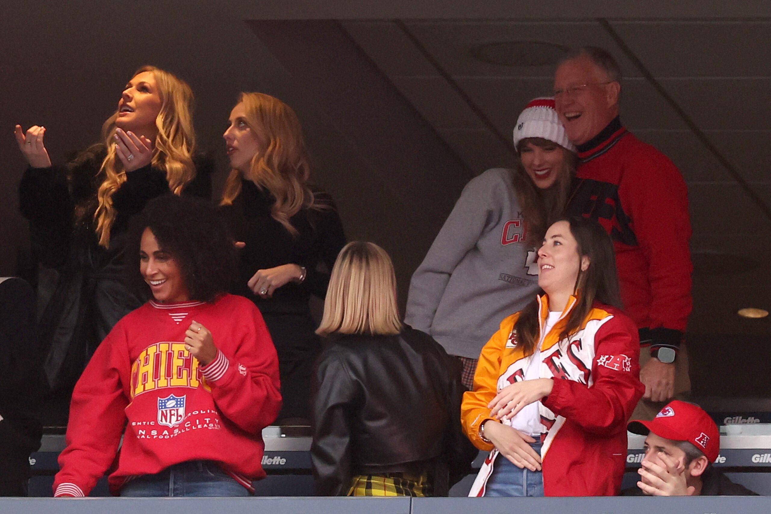 Brittany Mahomes looks on while Taylor Swift hugs her father, Scott Swift, with Alana Haim, right, while the Kansas City Chiefs and the New England Patriots play at Gillette Stadium on Dec. 17, 2023, in Foxborough, Massachusetts. (Maddie Meyer/Getty Images/TNS)
