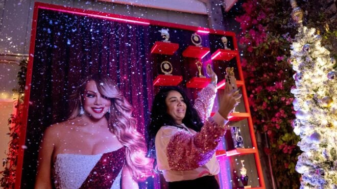 Wendy Carrillo takes a selfie with a picture at the pop-up Mariah Carey Holiday bar at The Mondrian Hotel on Dec. 5, 2025, in West Hollywood, California.
