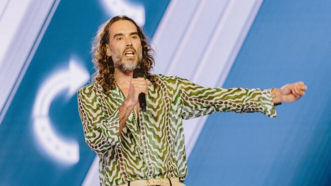 Russell Brand speaks during Turning Point's annual AmericaFest conference in Phoenix on Thursday, Dec. 18, 2025.