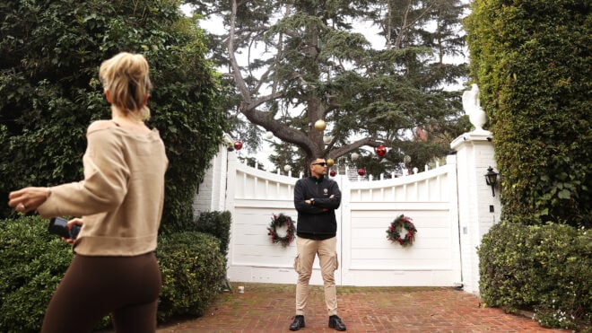 A private security guard stands outside the front gate of the Brentwood home of longtime Hollywood star Rob Reiner and his wife, who were found dead at the home on Sunday, on Dec. 15, 2025. (Christina House/Los Angeles Times/TNS)