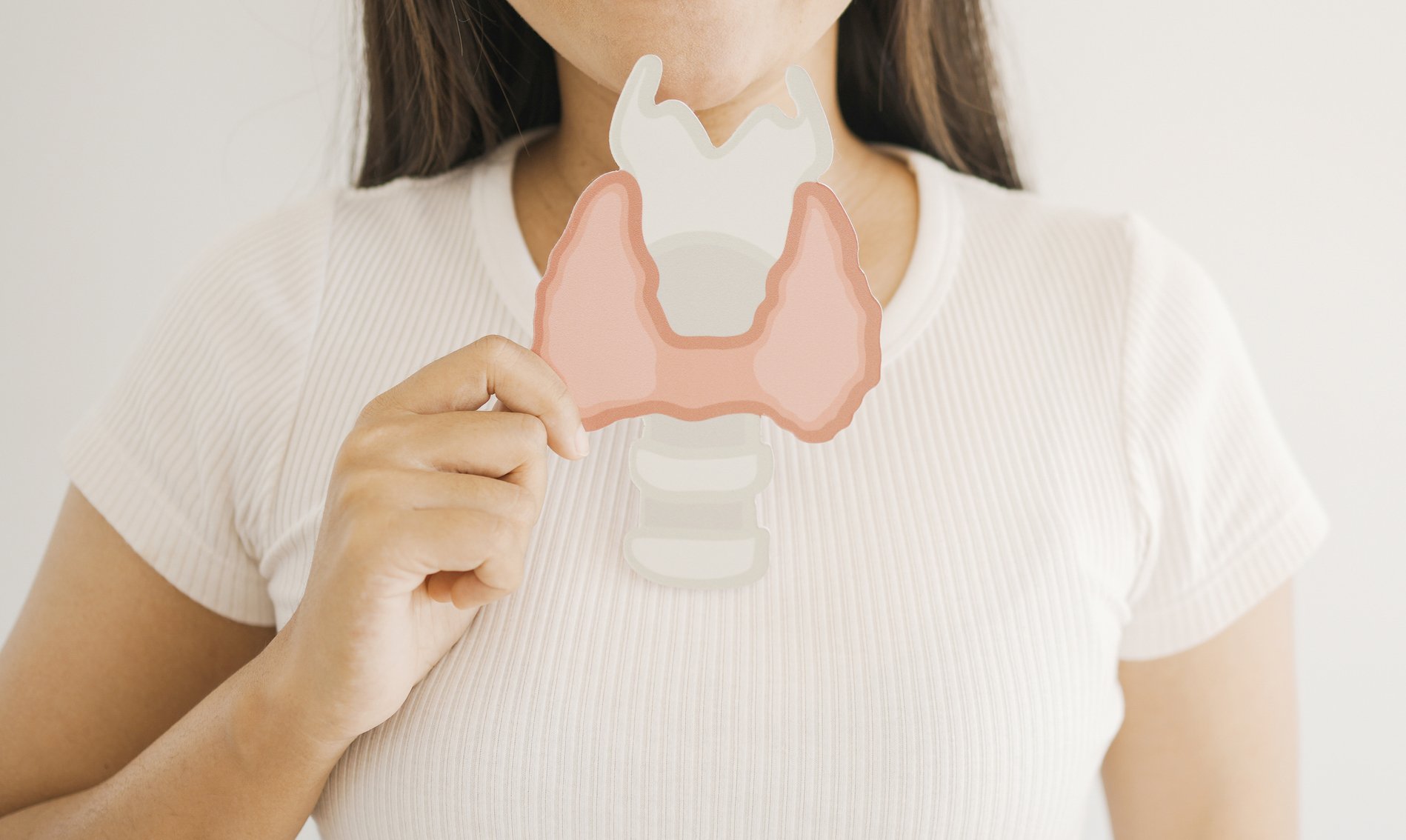 Woman holding Thyroid gland paper cutout