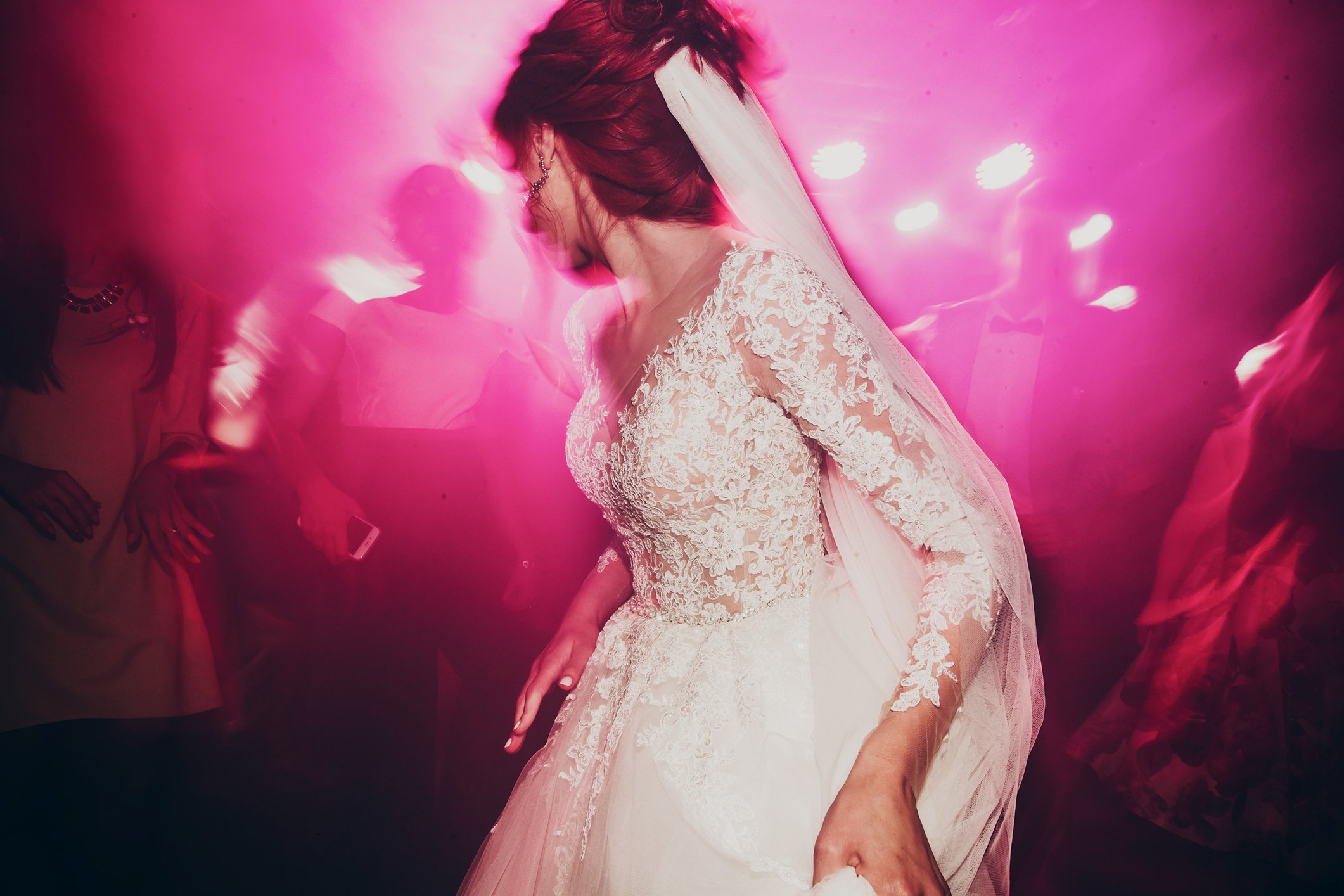 Bride dancing at wedding, looking away from the camera
