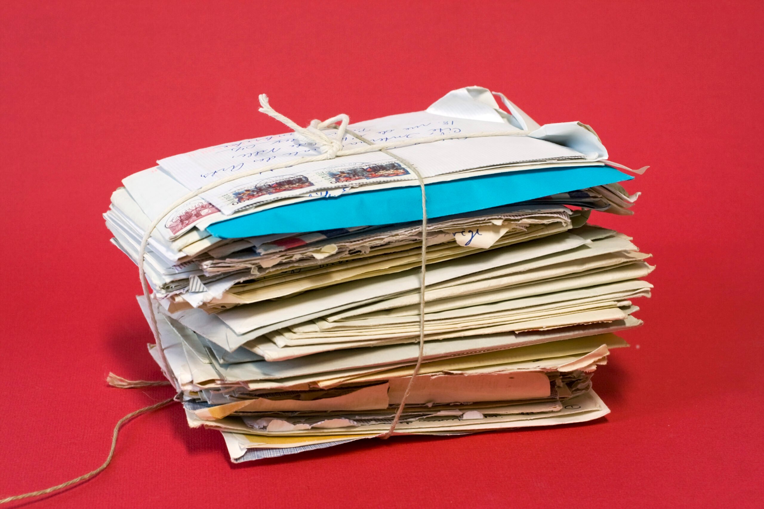 Bundle of old letters tied with string with red background