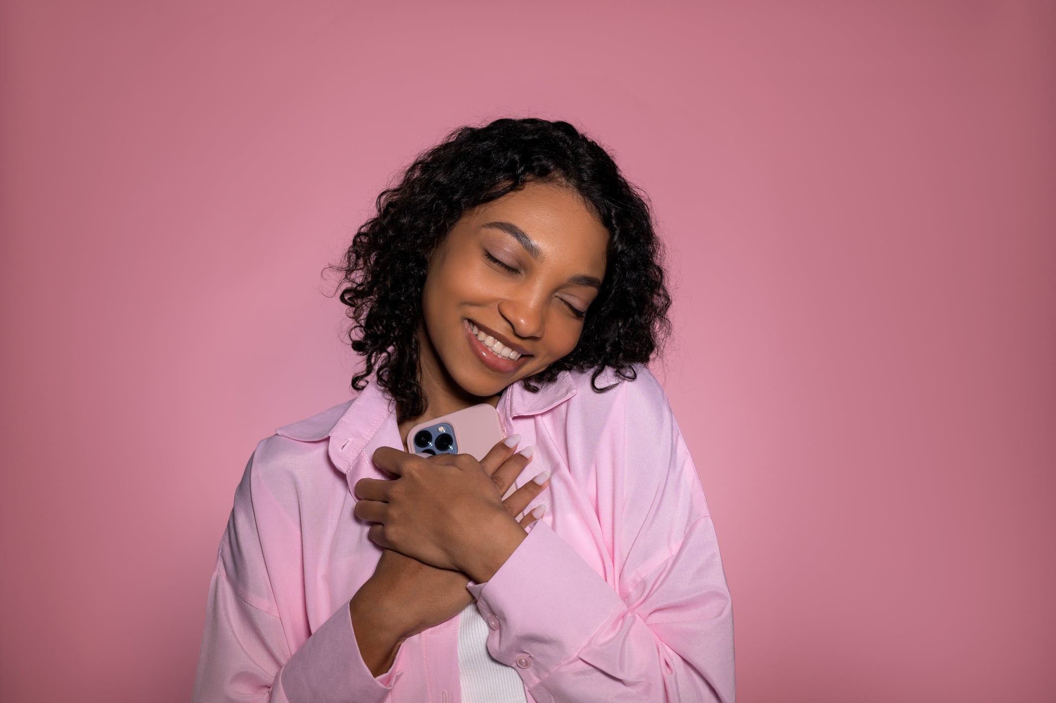 studio shot in pink color with cute girl with smartphone that recieved love message. In love,valentine's day