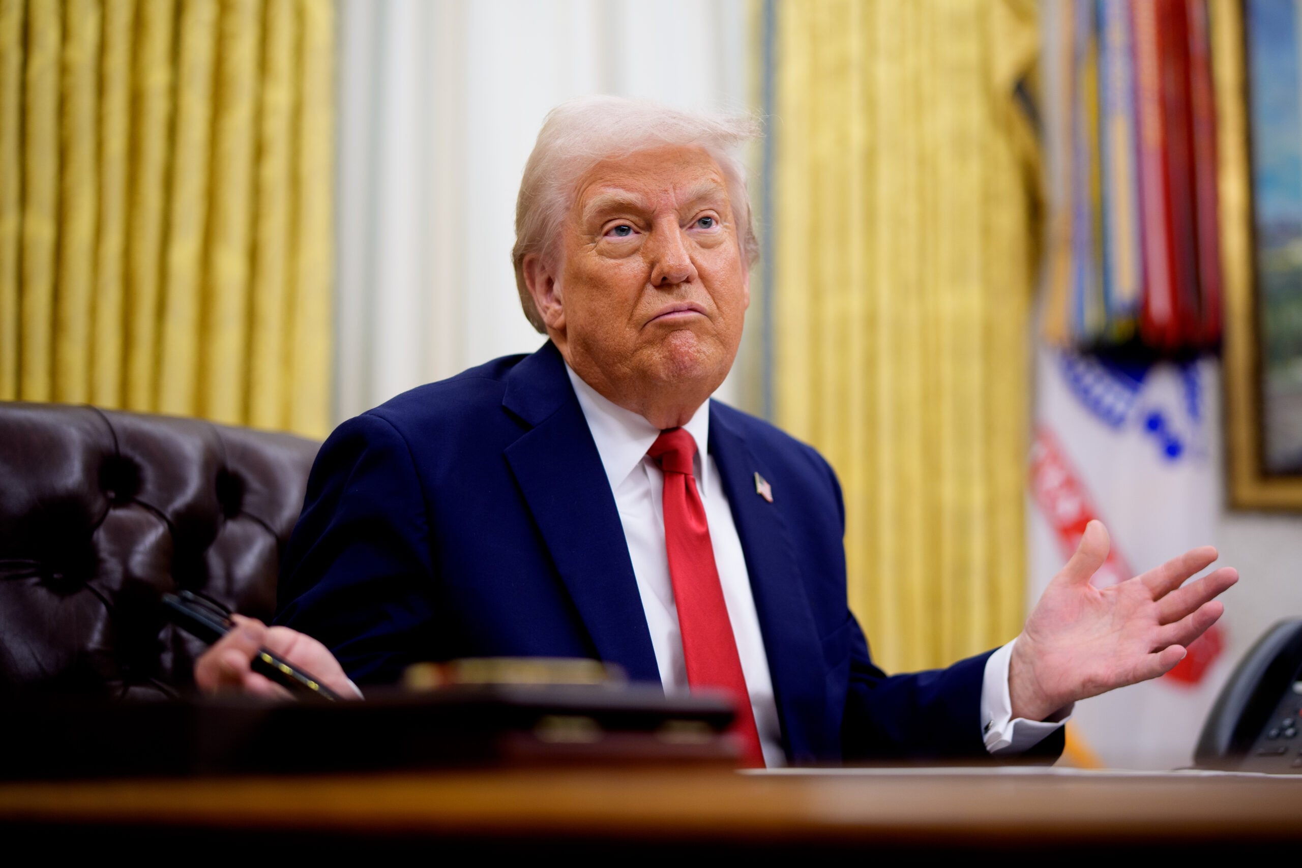 President Donald Trump gestures while speaking during an executive order signing event in the Oval Office of the White House