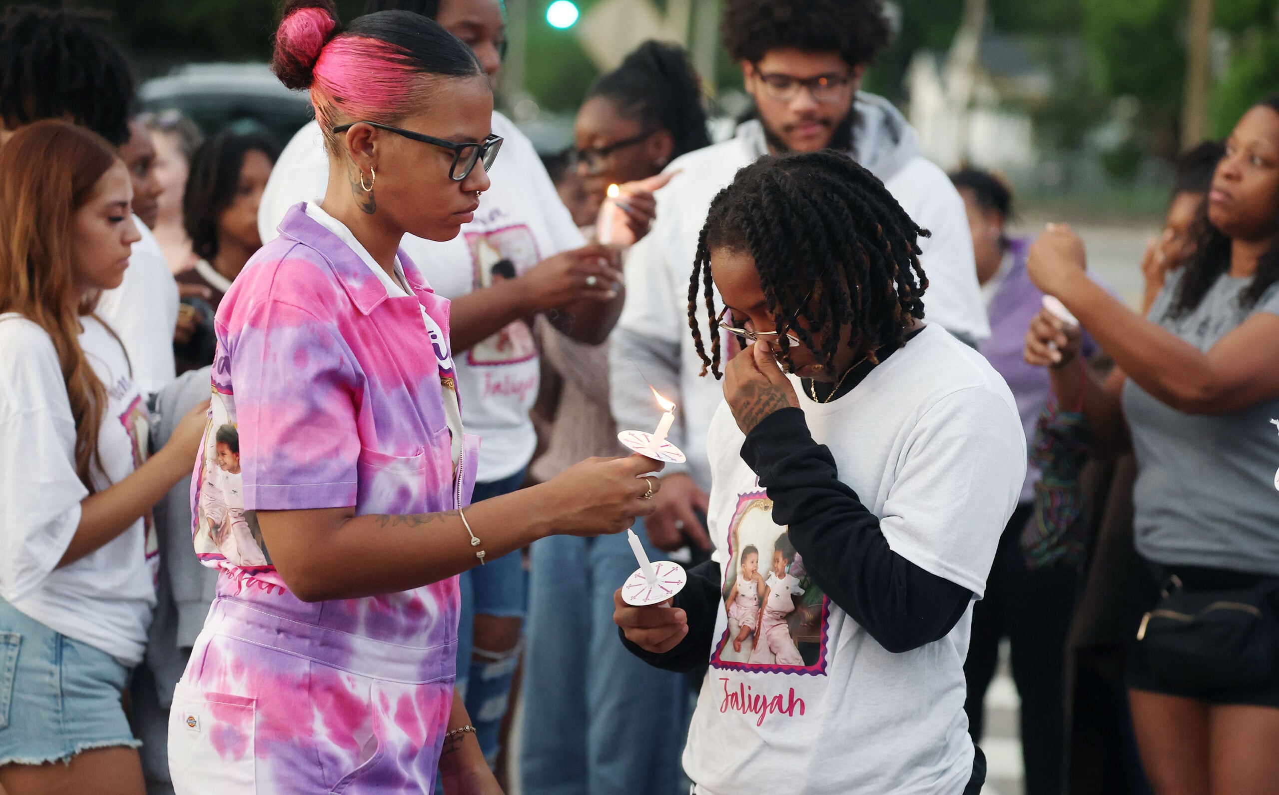 Mourners light candles during a community vigil for 2-year-old Tiana Rae Watts and 1-year-old Jaliyah Katherine Watts