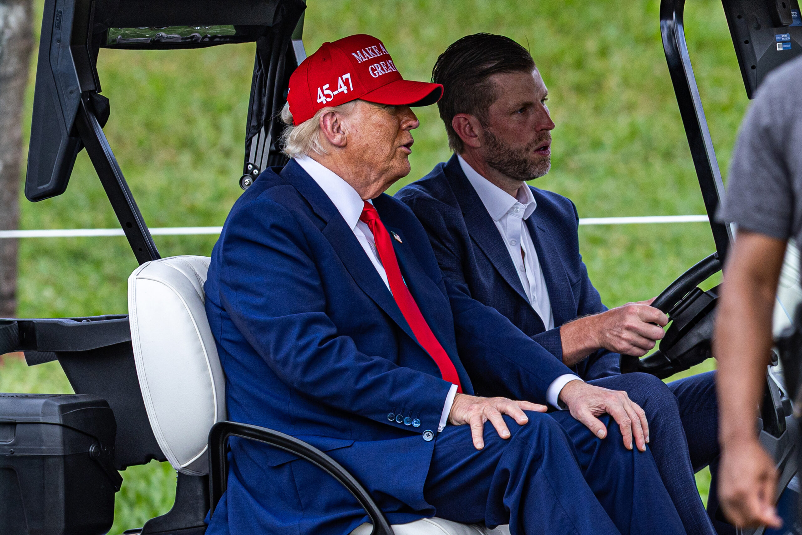 DORAL, FLORIDA - APRIL 03: U.S. President Donald Trump and his son Eric Trump drive in a golf cart after arriving in Marine One on the ninth hole during previews for LIV Golf Miami at Trump National Doral Miami on April 03, 2025 in Doral, Florida. (Photo by Lauren Sopourn/Getty Images)