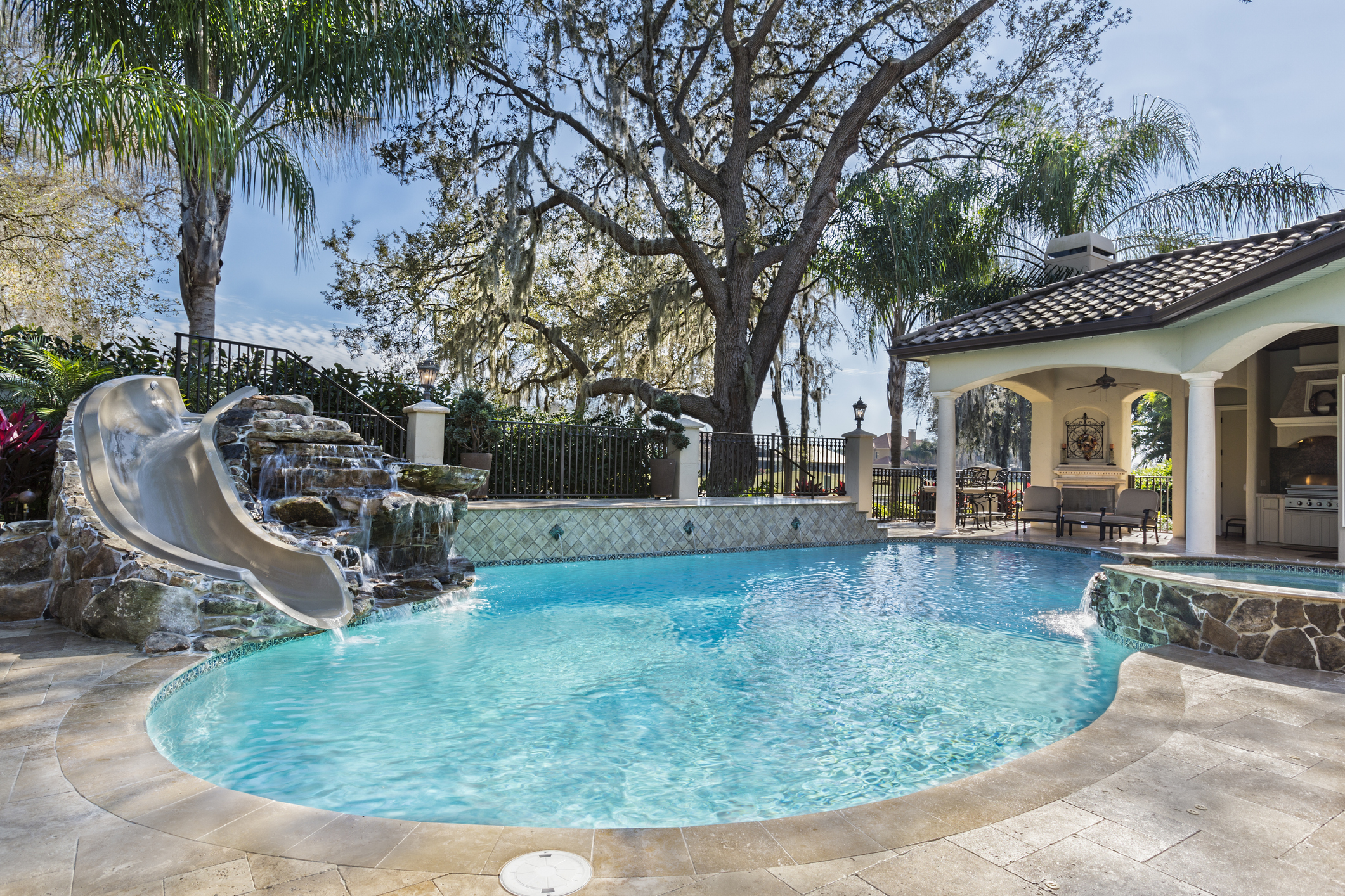 beautiful pool in home's backyard with a slide