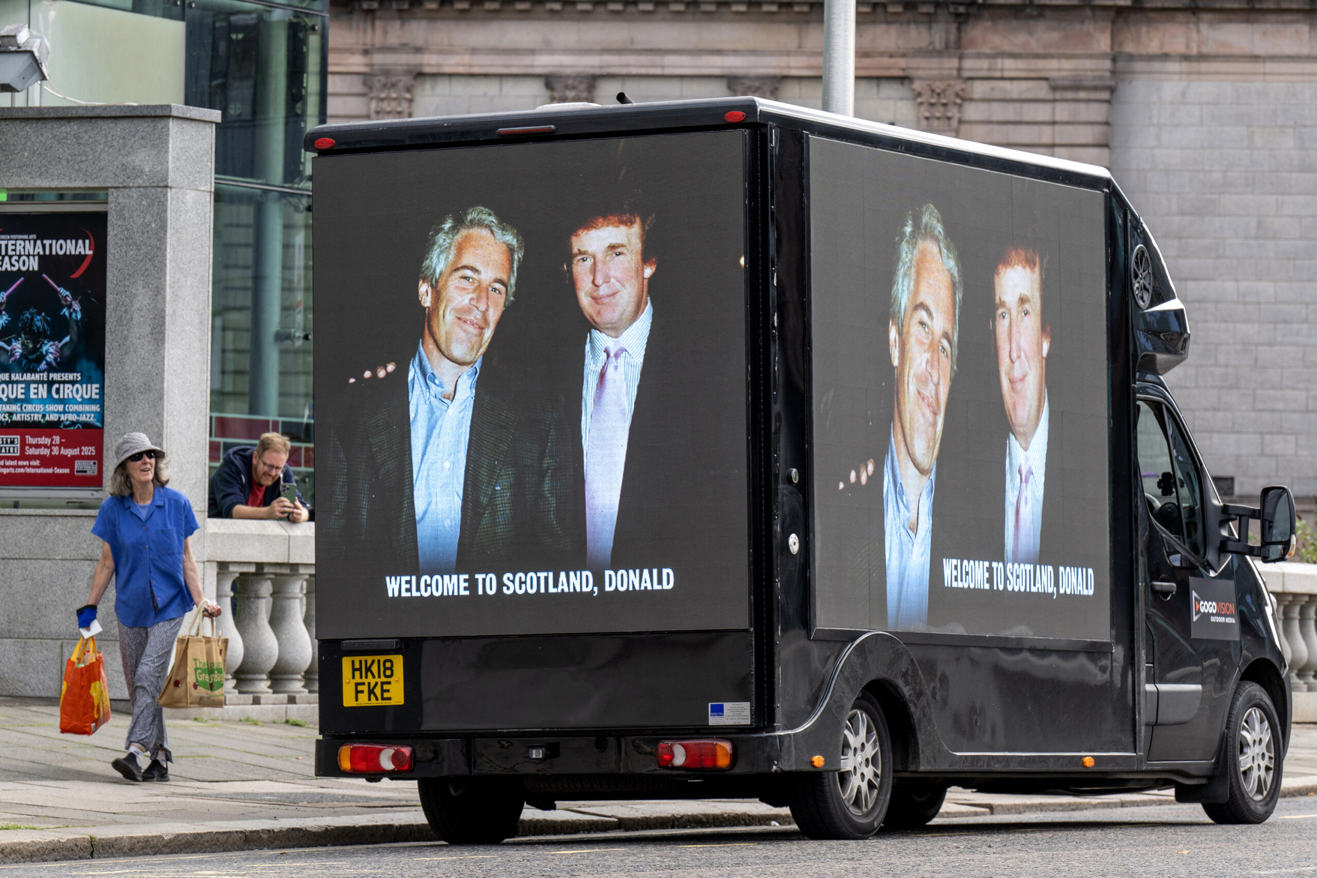 A photograph of President Donald Trump and convicted child sex offender Jeffery Epstein is displayed on the side of a van