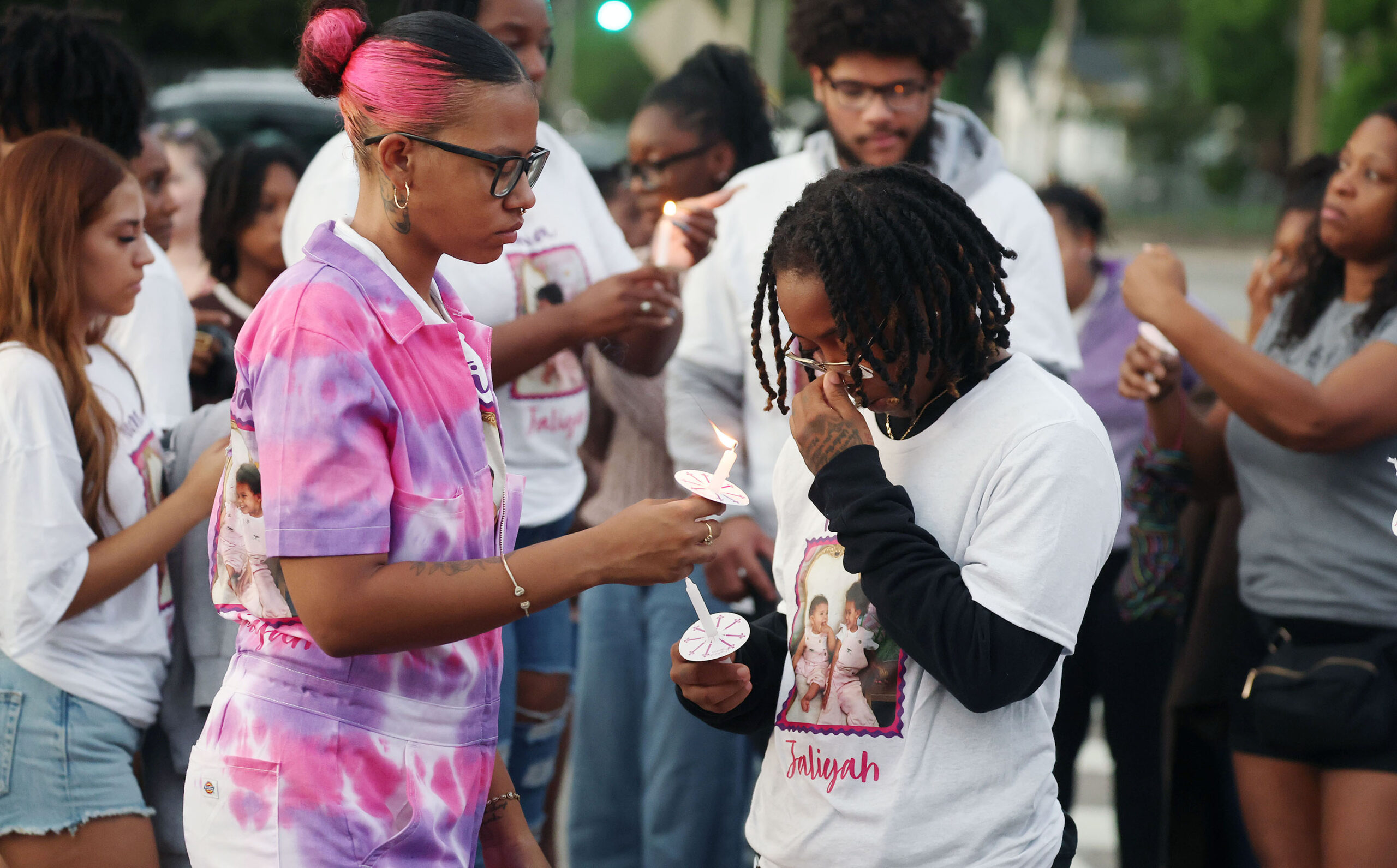 Mourners light candles during a community vigil for 2-year-old Tiana Rae Watts and 1-year-old Jaliyah Katherine Watts